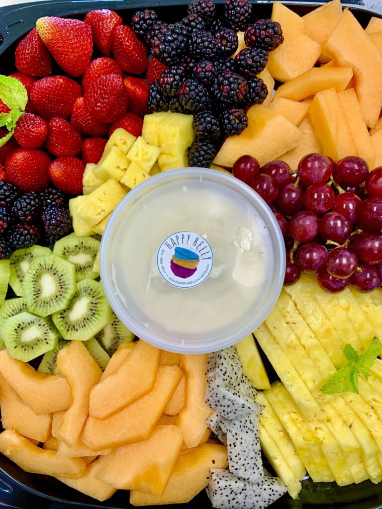 Fresh fruit platter with a colorful assortment of sliced seasonal fruits from Happy Belly catering